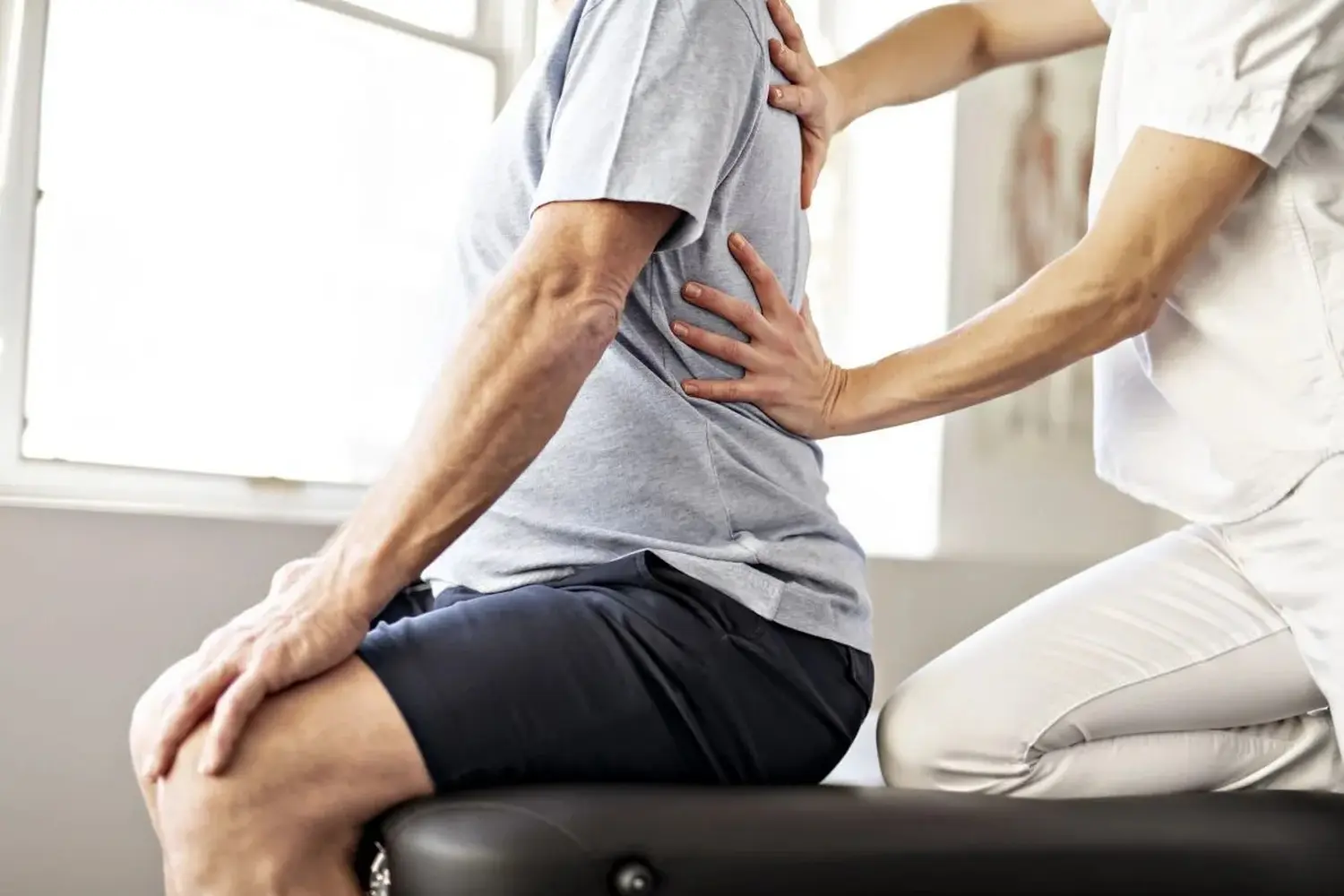 Ein Mitarbeiter der modernen Rehabilitationsphysiotherapie mit einem älteren Klienten