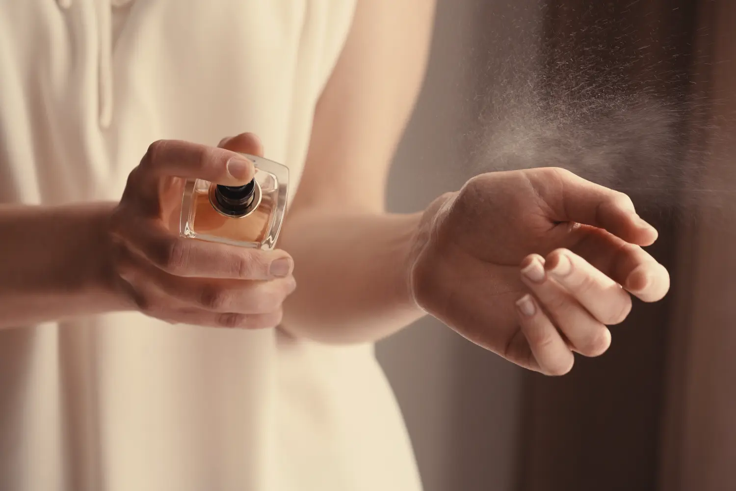 Schöne junge Frau mit einer Flasche Parfüm zu Hause, Nahaufnahme